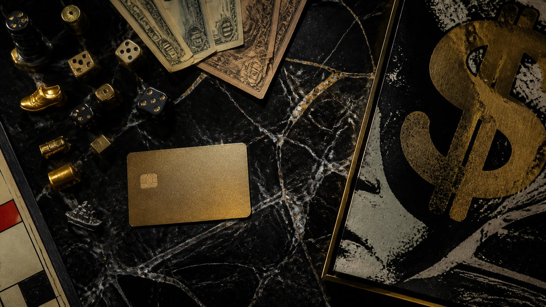 Luxury overhead flat-lay on black marble with scattered board-game tokens, dice, vintage play money, a gold credit card and t