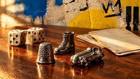 Nostalgic still life of vintage generic metal game pieces, dice and blank cards arranged on a warm wooden table with subtle s