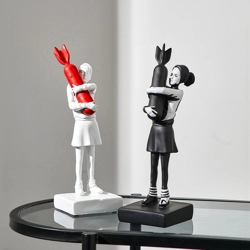 Iconic Banksy Hugging Bomb Girl statue in red and white, representing the intersection of art and activism